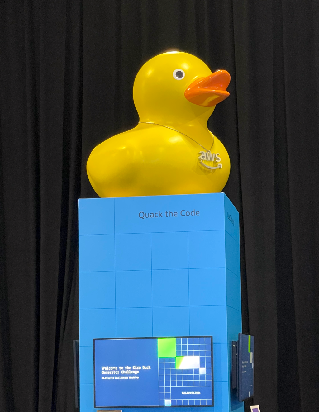 A large yellow rubber duck on a pedestal labelled Quack the Code