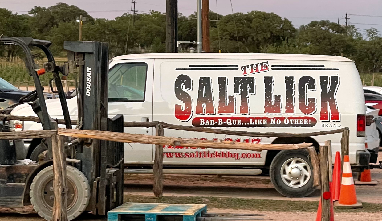 A white van in the parking lot of the Salt Lick barbecue restaurant