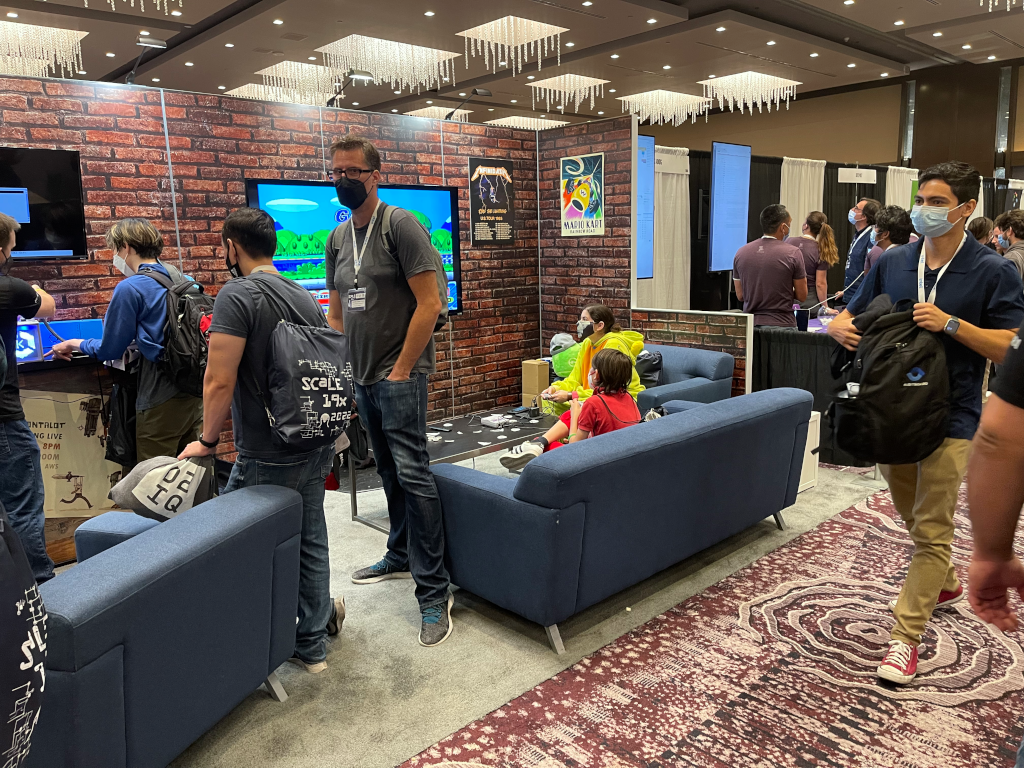 The AWS Booth showing people playing a video game