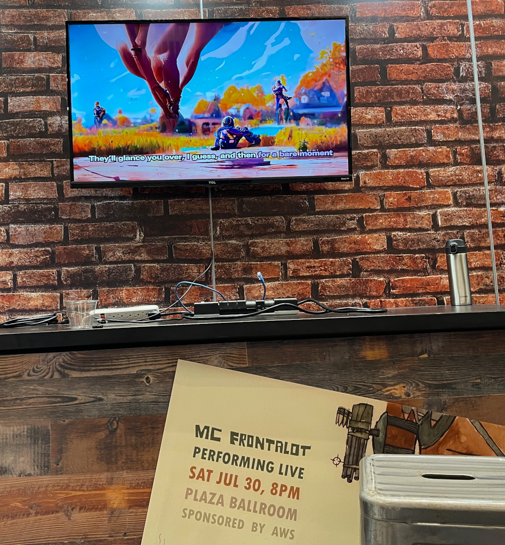AWS Booth Picture Showing a Television Screen Playing Frontalot Videos